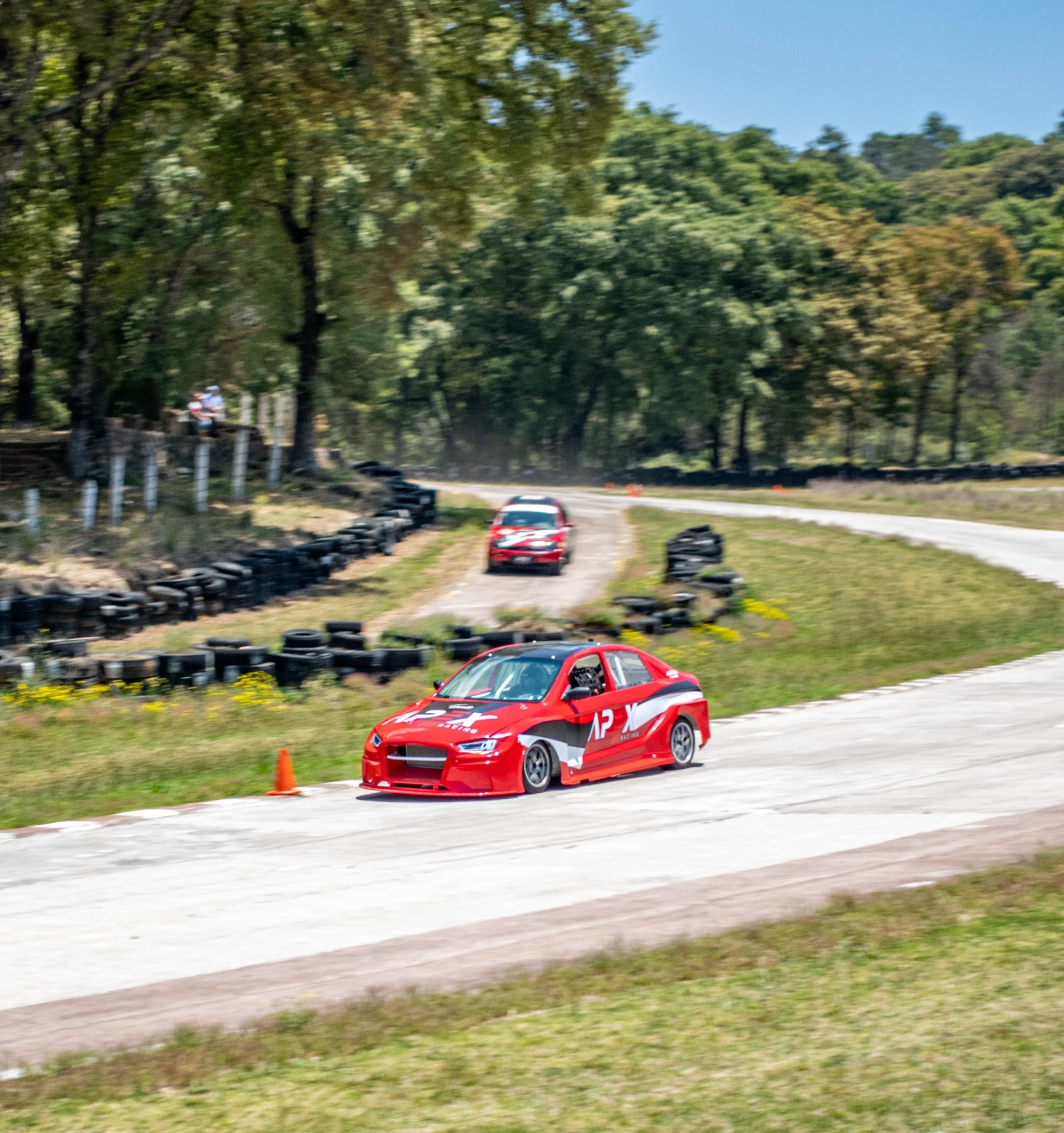 Auto rojo de APEX Racing recorriendo un circuito